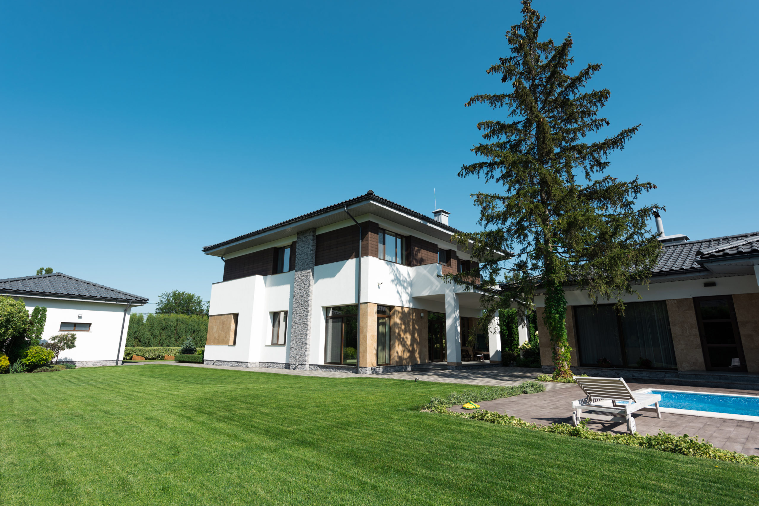 view of new modern house with swimming pool and green lawn view of new modern house with swimming pool and green lawn